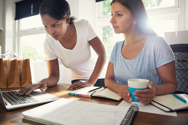 Two young female businesswomen doing research