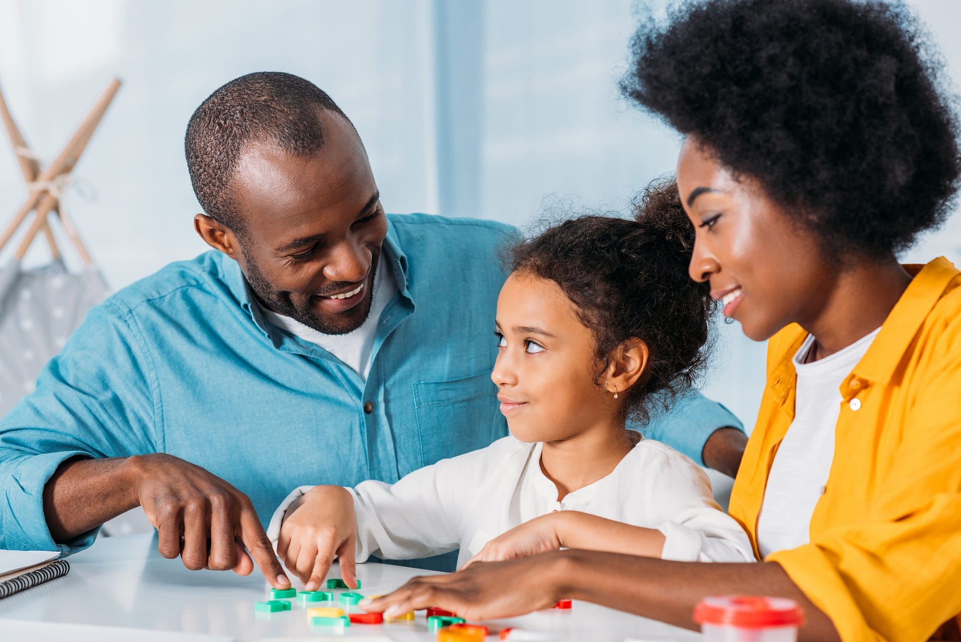 african american parents teaching daughter mathematics at home