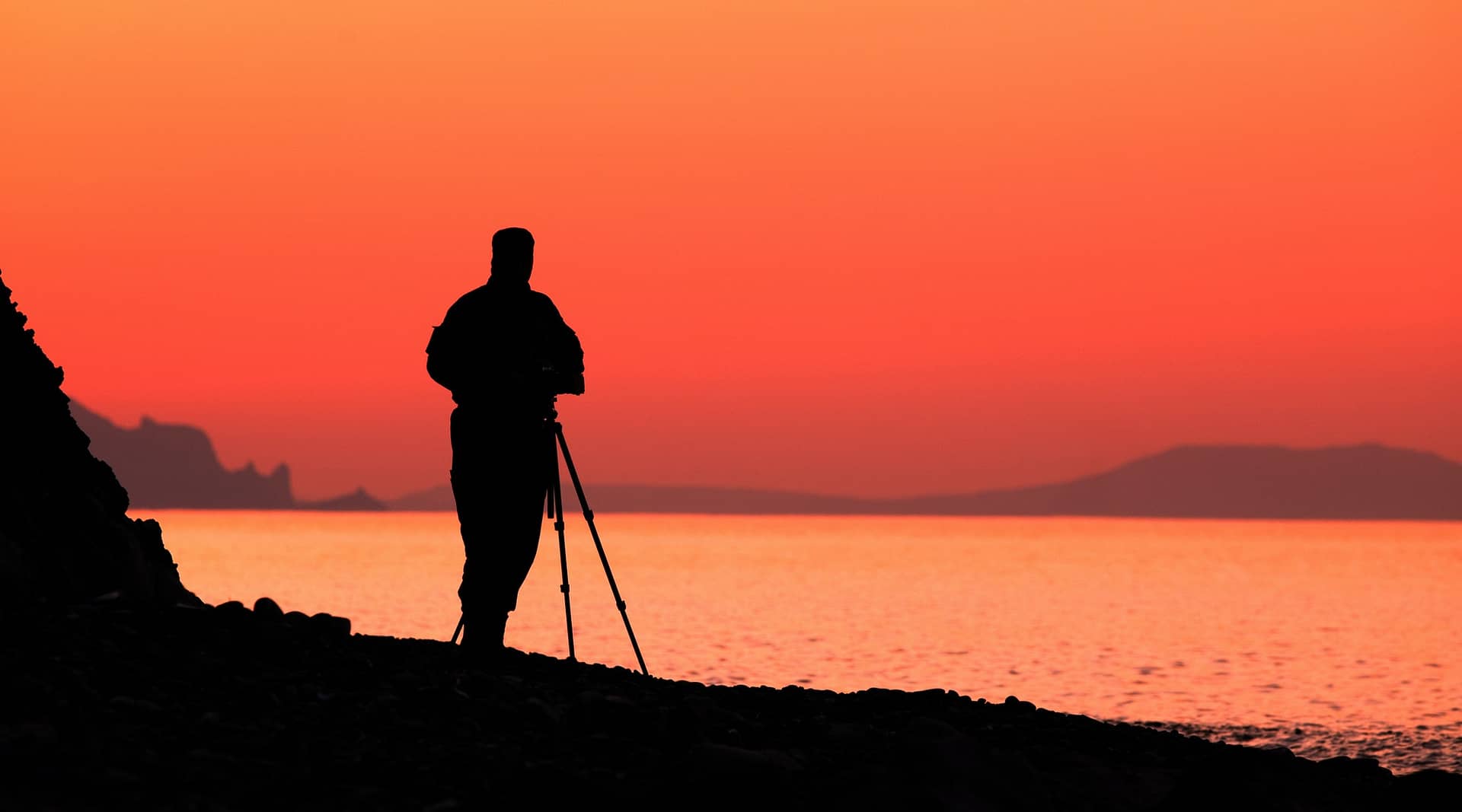 Silhouette of a male photographer by the sea